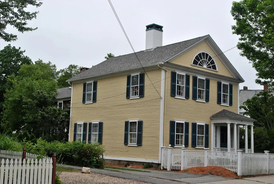 Yellow Federal-style house with a fanlight window in Falmouth
